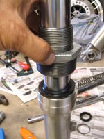 Seating the shock cover using the 1-1/2 to 2-inch bushing end tool as a sliding hammer.